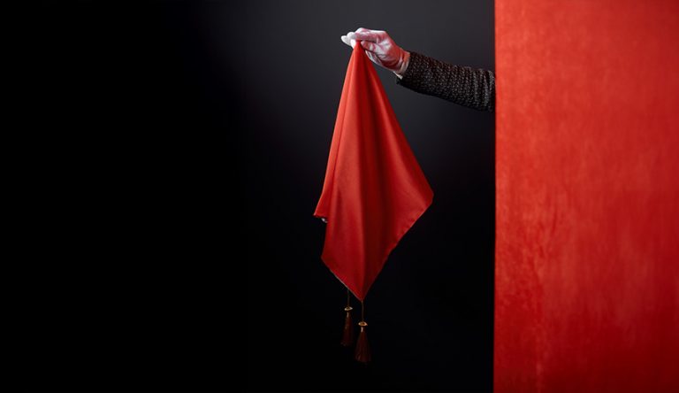 A magician holds a red flag