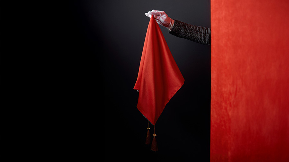 A magician holds a red flag