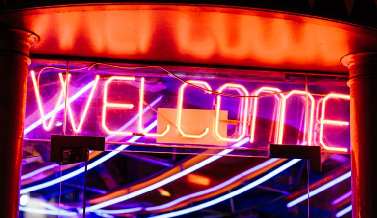 A neon sign that says Welcome