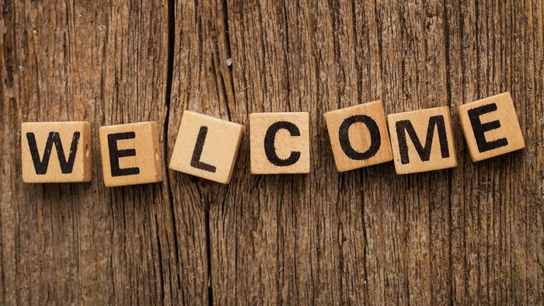 a wooden wall with the tile letters spelling welcome